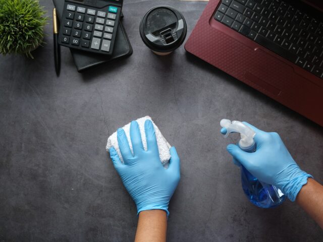 person in blue long sleeve shirt sitting beside black laptop computer